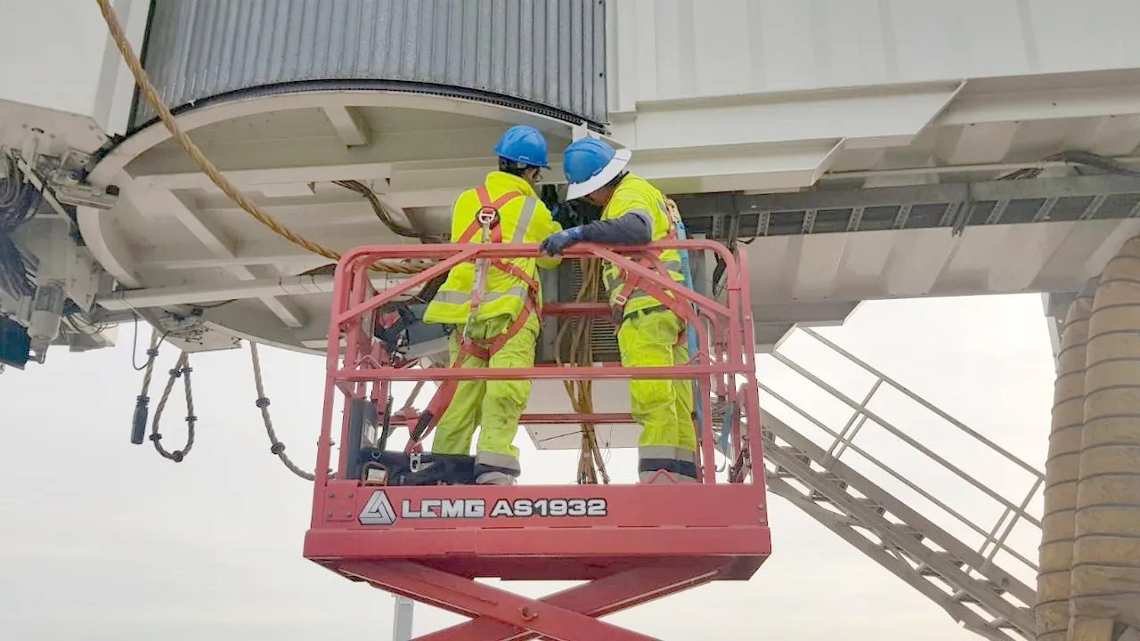 Cuadrilla de APS LATAM trabajando bajo una pasarela de embarque desde una plataforma elevadora
