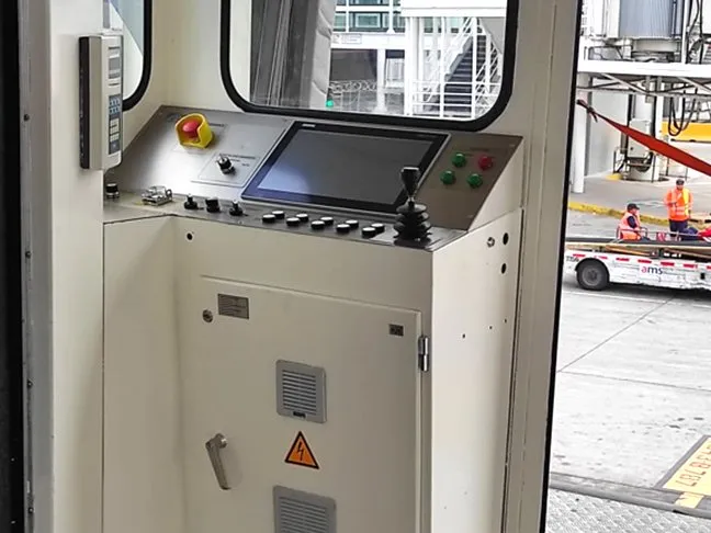 La misma cabina después de la modernización: nuevo pupitre de control con pantalla, joystick y señalización de seguridad