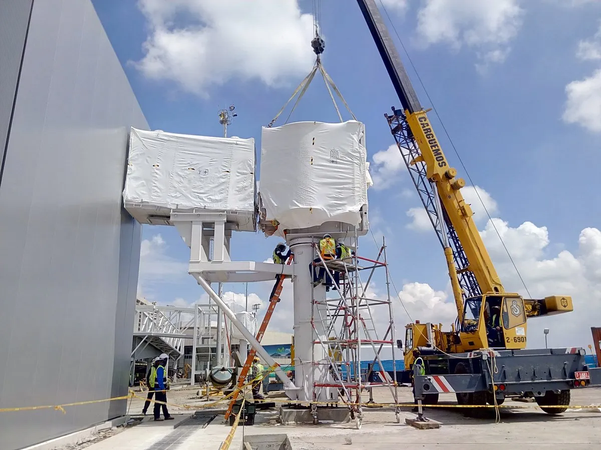 Grúa izando el módulo de una pasarela de embarque durante su instalación en el aeropuerto de Cali, Colombia