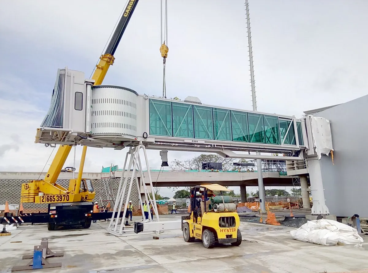 Montaje de una pasarela de embarque nueva con grúa en un aeropuerto de Colombia